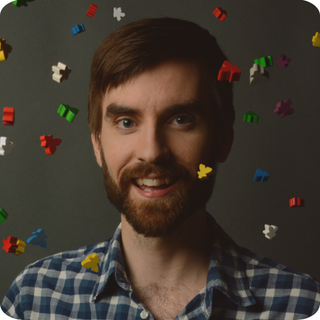 David Van Drunen surrounded by colourful meeples.
