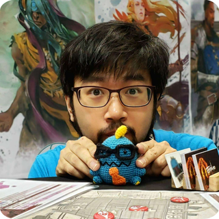 Derek Chung standing behind a crochet critter.